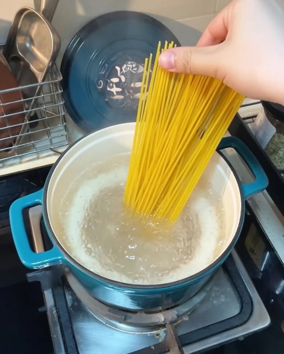 Spaghetti immersi in una pentola di acqua bollente.