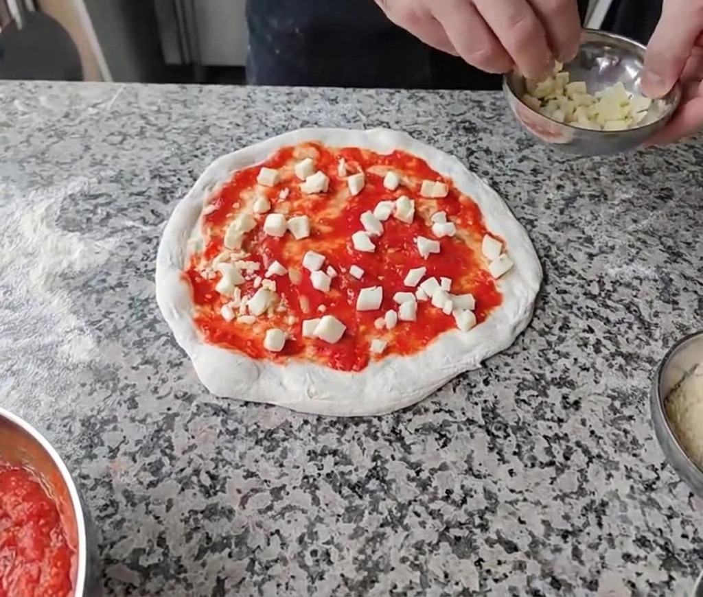 Cospargere i formaggi bianchi tagliati a cubetti sopra la base di pomodoro.