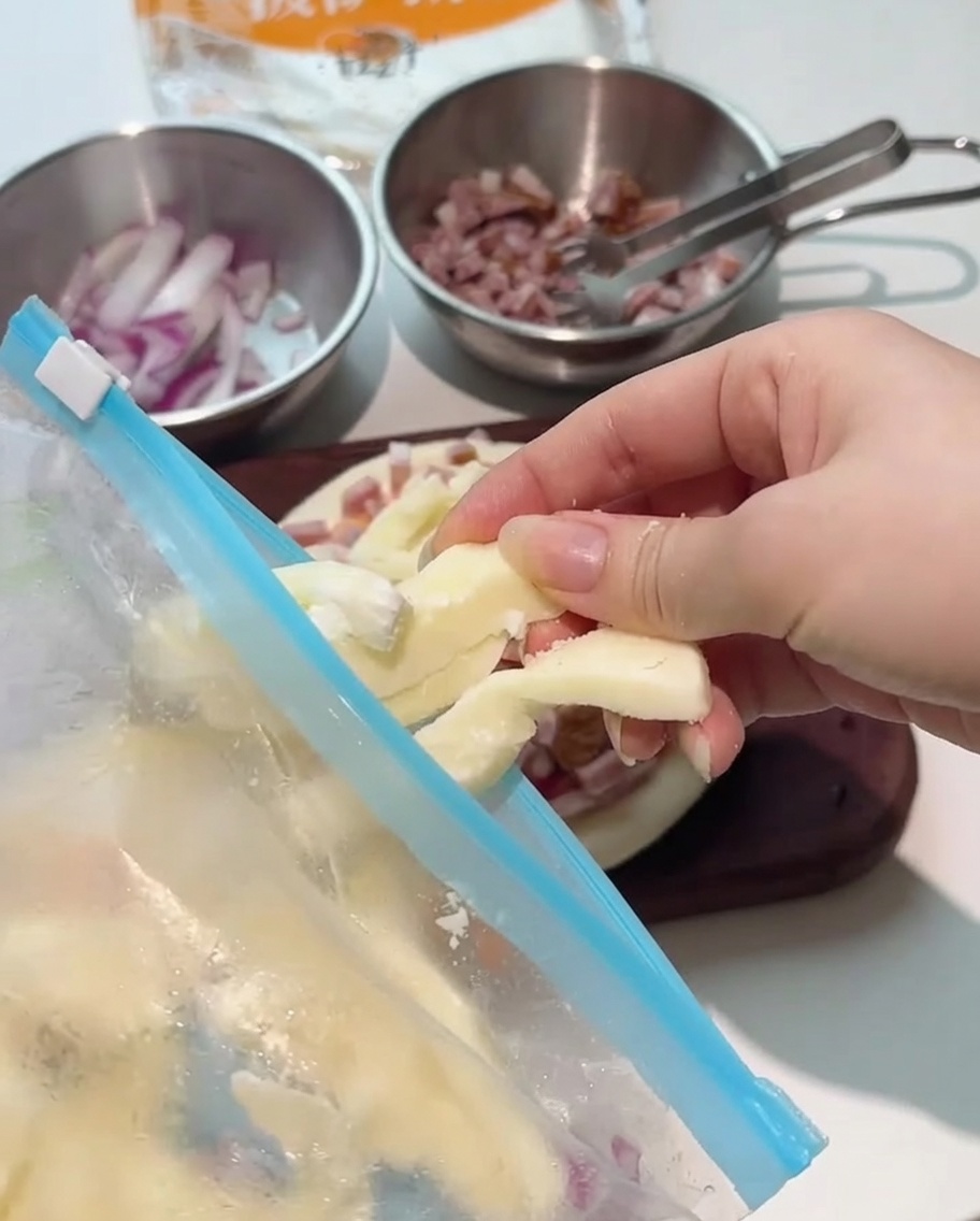 Strisce spesse di mozzarella posizionate sopra la pizza condita.