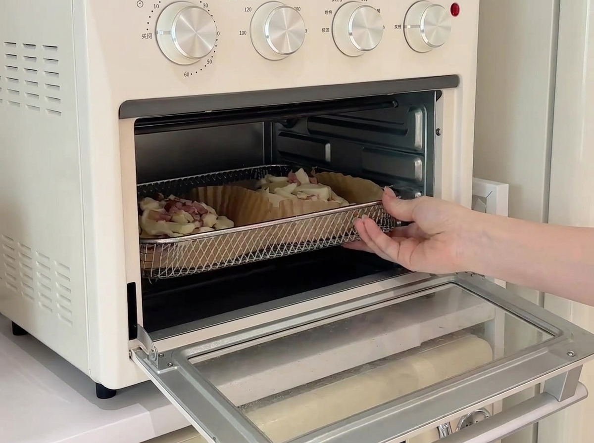 Due mini pizze su una griglia allinterno di un piccolo forno da banco in fase di cottura.