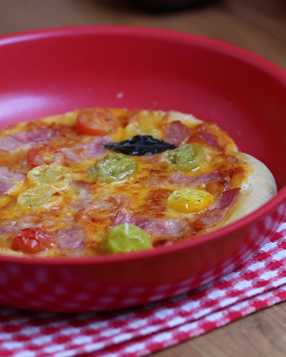 Una forchetta usata per bucherellare la superficie centrale della base della pizza cruda.