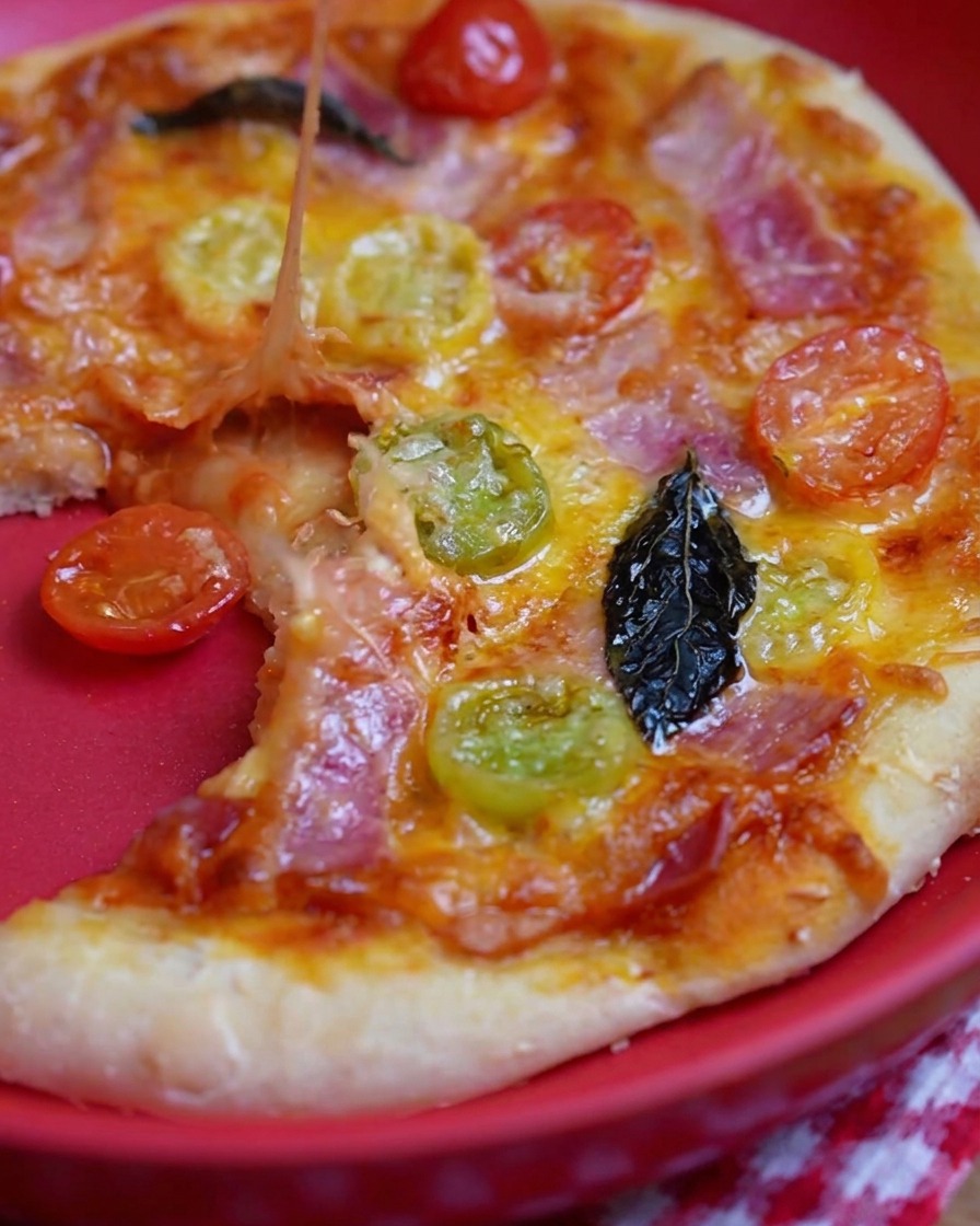 Un cucchiaio di metallo che spalma salsa di pomodoro rossa su una base di pizza cruda.