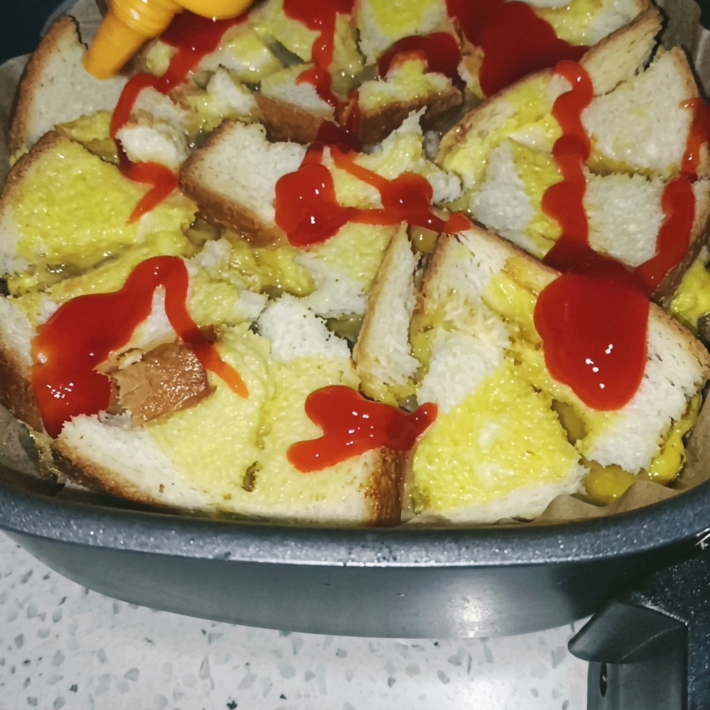Un pennello che spalma salsa di pomodoro rossa sopra la base di pane e uovo cotta nella friggitrice ad aria.