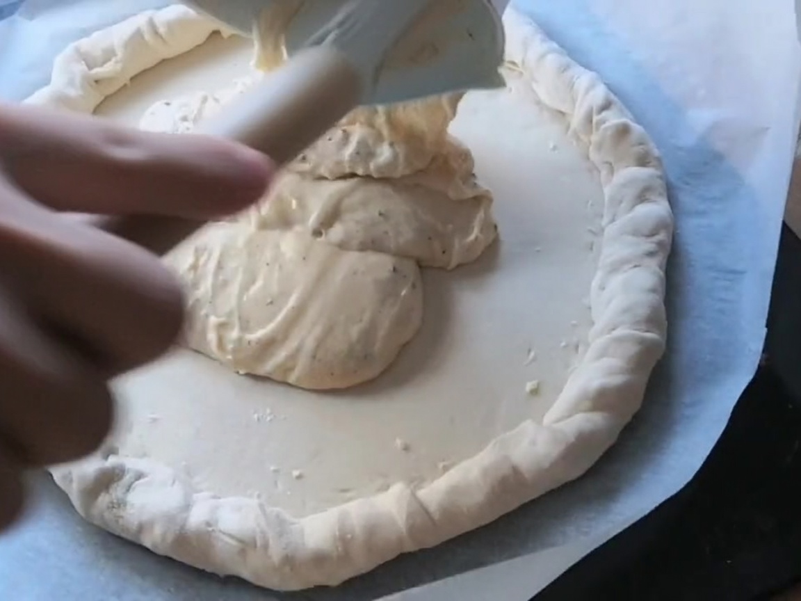 Fette di pepperoni e salame disposte sulla pizza coperta di salsa.