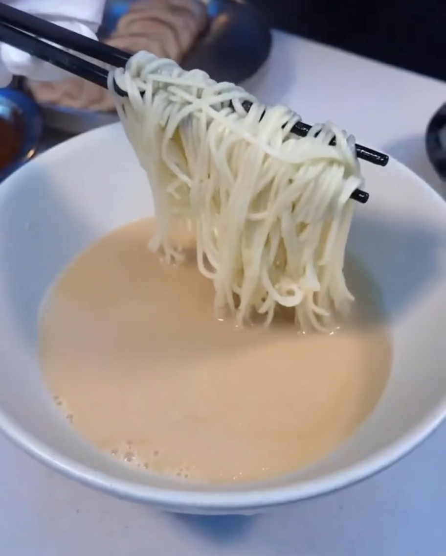 Noodles per ramen fumanti trasferiti in una ciotola di zuppa.