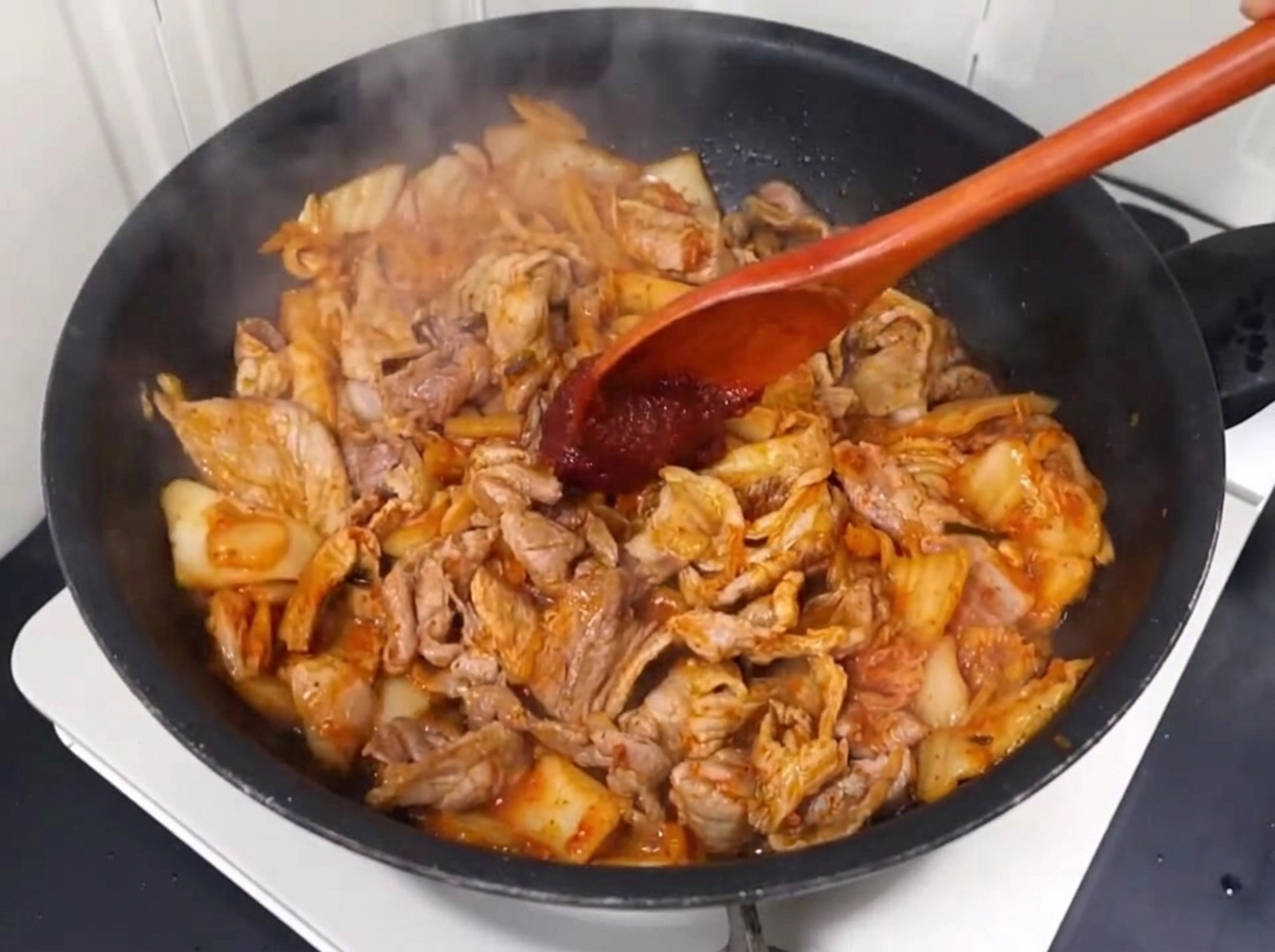 Pasta e polvere di peperoncino aggiunti al salto di carne e kimchi.