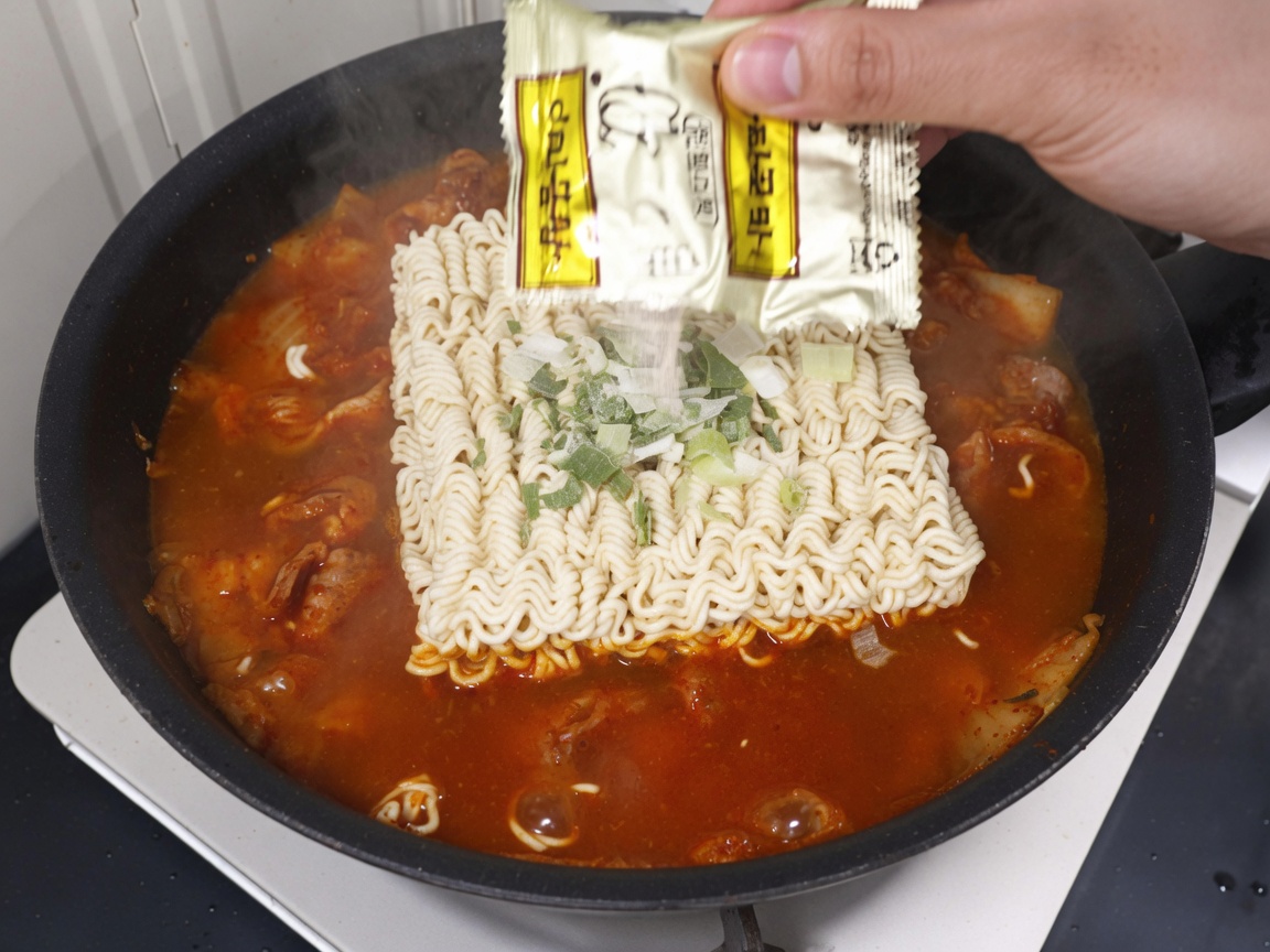 Bustina di condimento versata sui noodles in brodo.