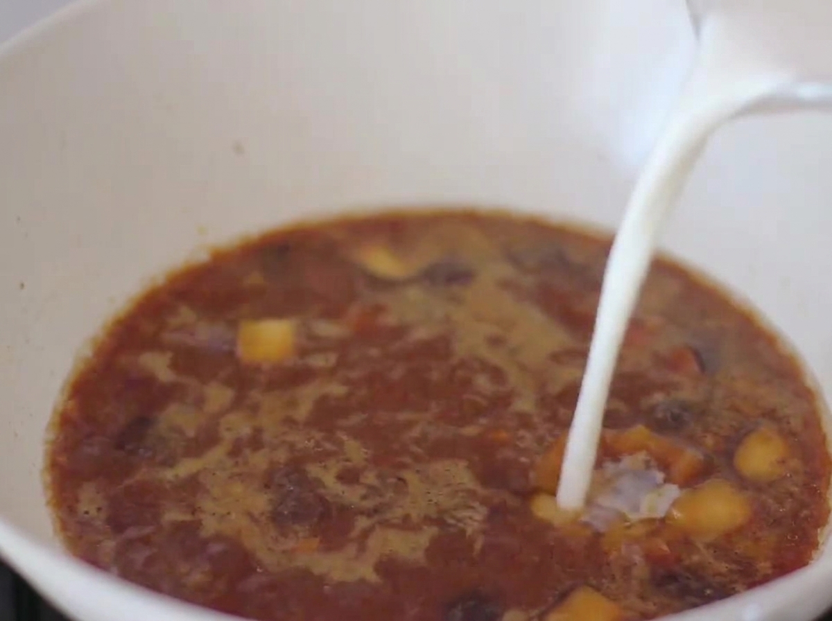 Il latte viene versato nel brodo a base di miso nella padella.