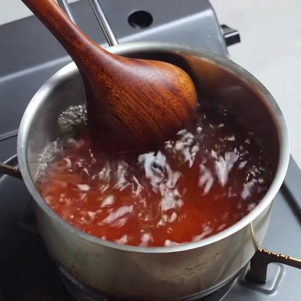 Brodo di ramen che bolle in una casseruola mentre viene mescolato.