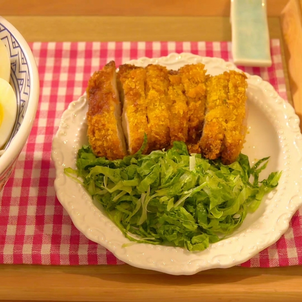 La cotoletta di pollo premuta con decisione su un letto di pangrattato panko.