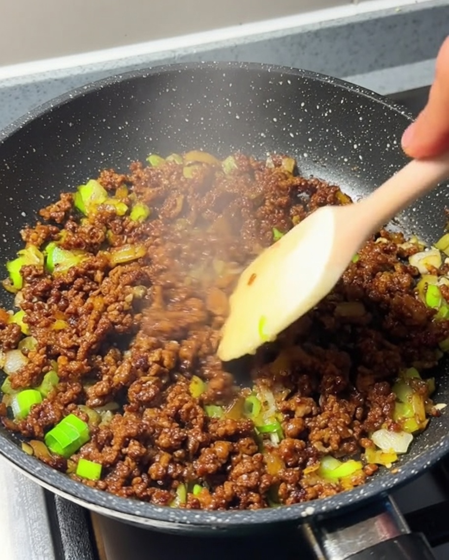 Carne macinata rosolata e ben distribuita nella padella.
