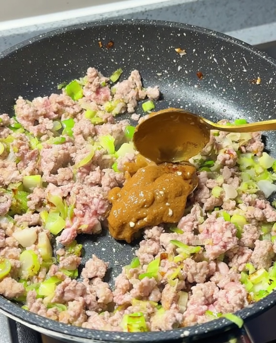 Pasta di miso chiara aggiunta alla carne in padella.