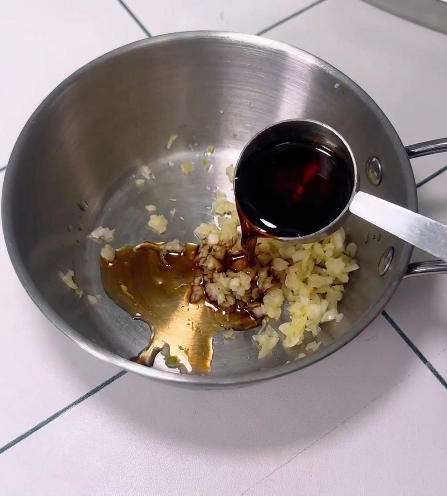 Una ciotola contenente un mix di aglio, pasta di peperoncino e altri ingredienti per la salsa.