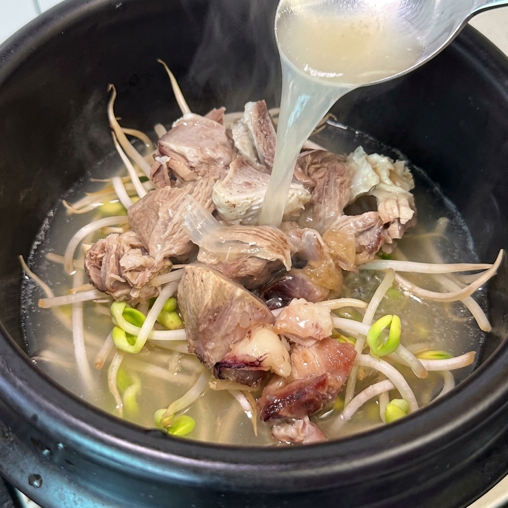 Un mestolo che versa brodo di ossa caldo e aromatico in una pentola di coccio.