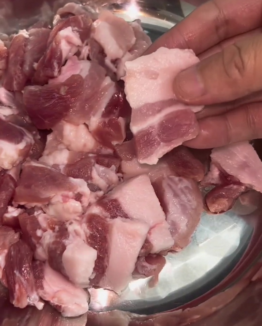 Sottili fette uniformi di pancetta di maiale disposte in una ciotola dacciaio.