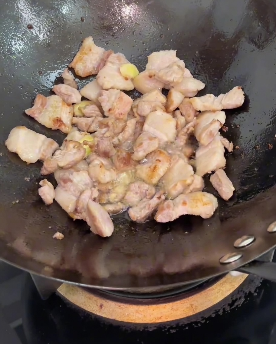 Salsa di soia versata nel wok sulla pancetta e lo zenzero.
