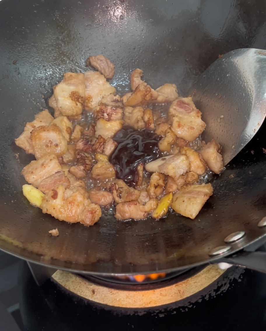 Salsa di ostriche scura mescolata con la pancetta dorata nel wok.