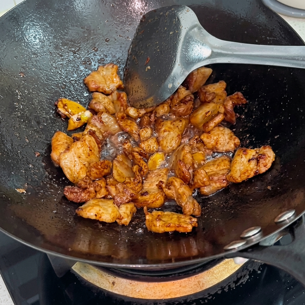 Zucchero bianco cosparso sulla pancetta lucida nel wok.