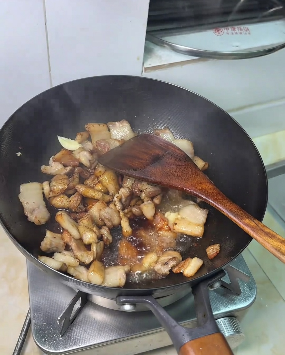 Un cucchiaino di zucchero aggiunto al composto di maiale e salsa di soia.