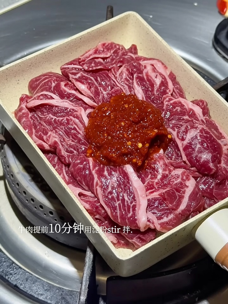 Straccetti di manzo sfrigolanti in padella, ricoperti da una ricca salsa piccante coreana rossa.