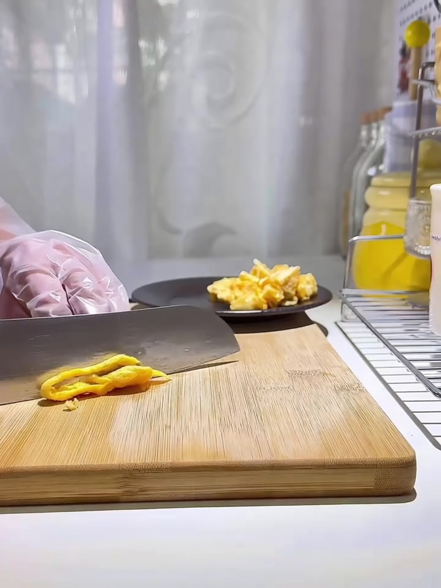 Una pila di strisce di uovo dorate su un tagliere di legno.