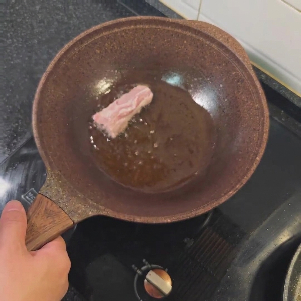 Costine di maiale che friggono in olio caldo fino a doratura.
