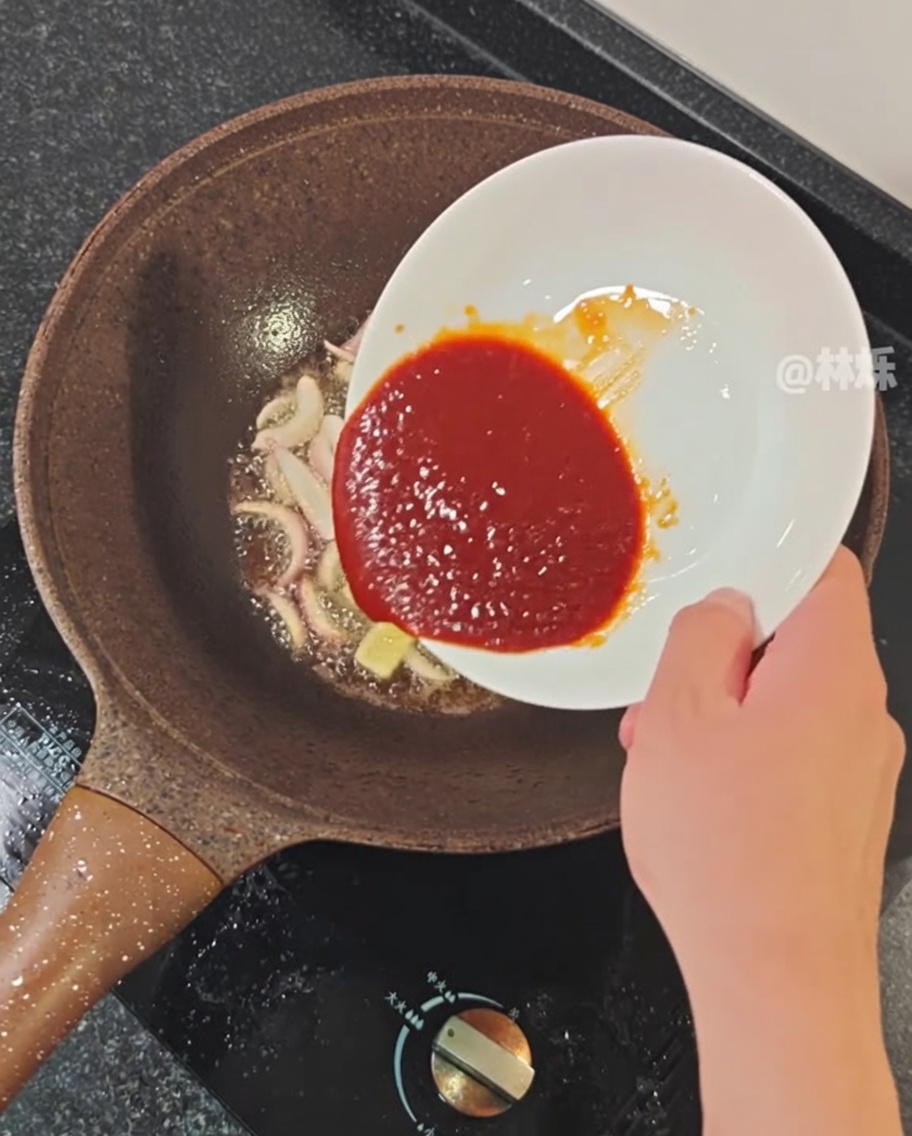 Salsa piccante versata nella padella con gli aromi soffritti.