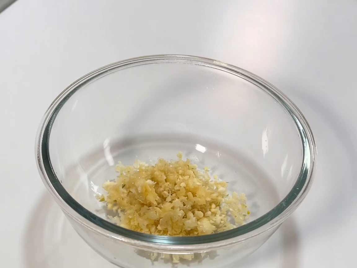 Ciotola di vetro contenente la miscela di pasta di peperoncino, salsa di soia e aromi per la salsa di brasatura.