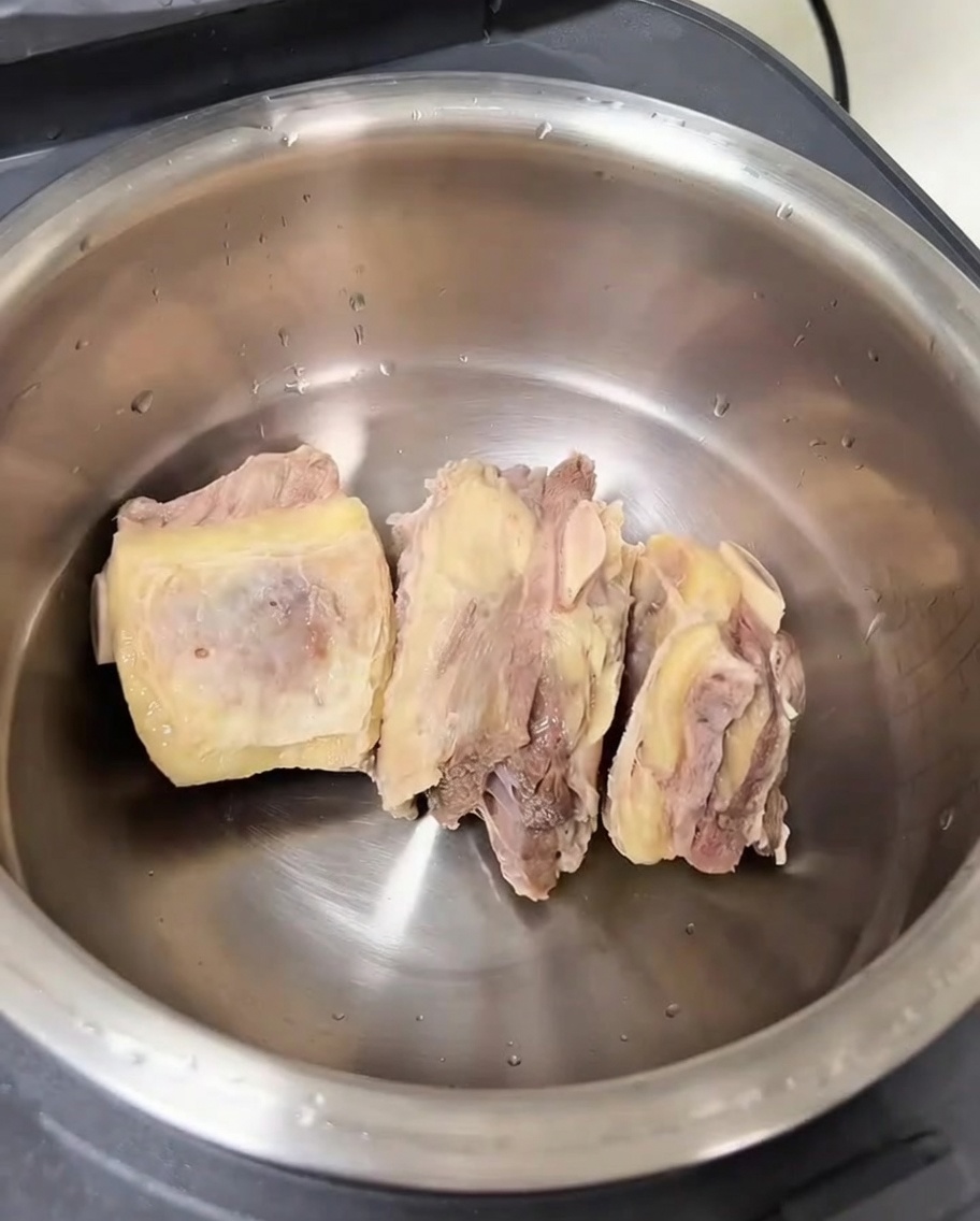Il vaso interno di un cuociriso contenente costine di manzo pulite e vari aromi.