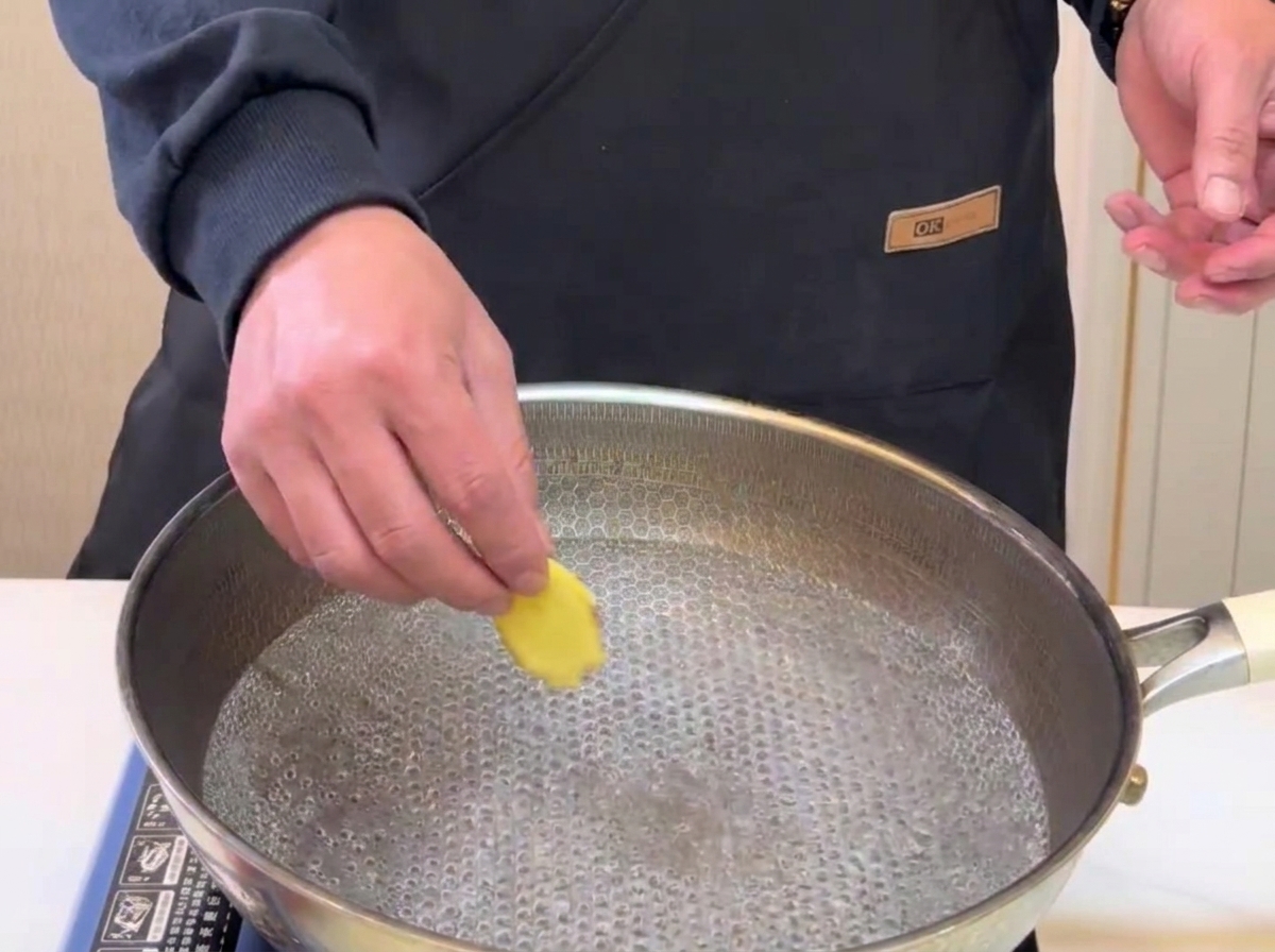 Fette di zenzero gettate in una pentola dacqua bollente per sbollentare.