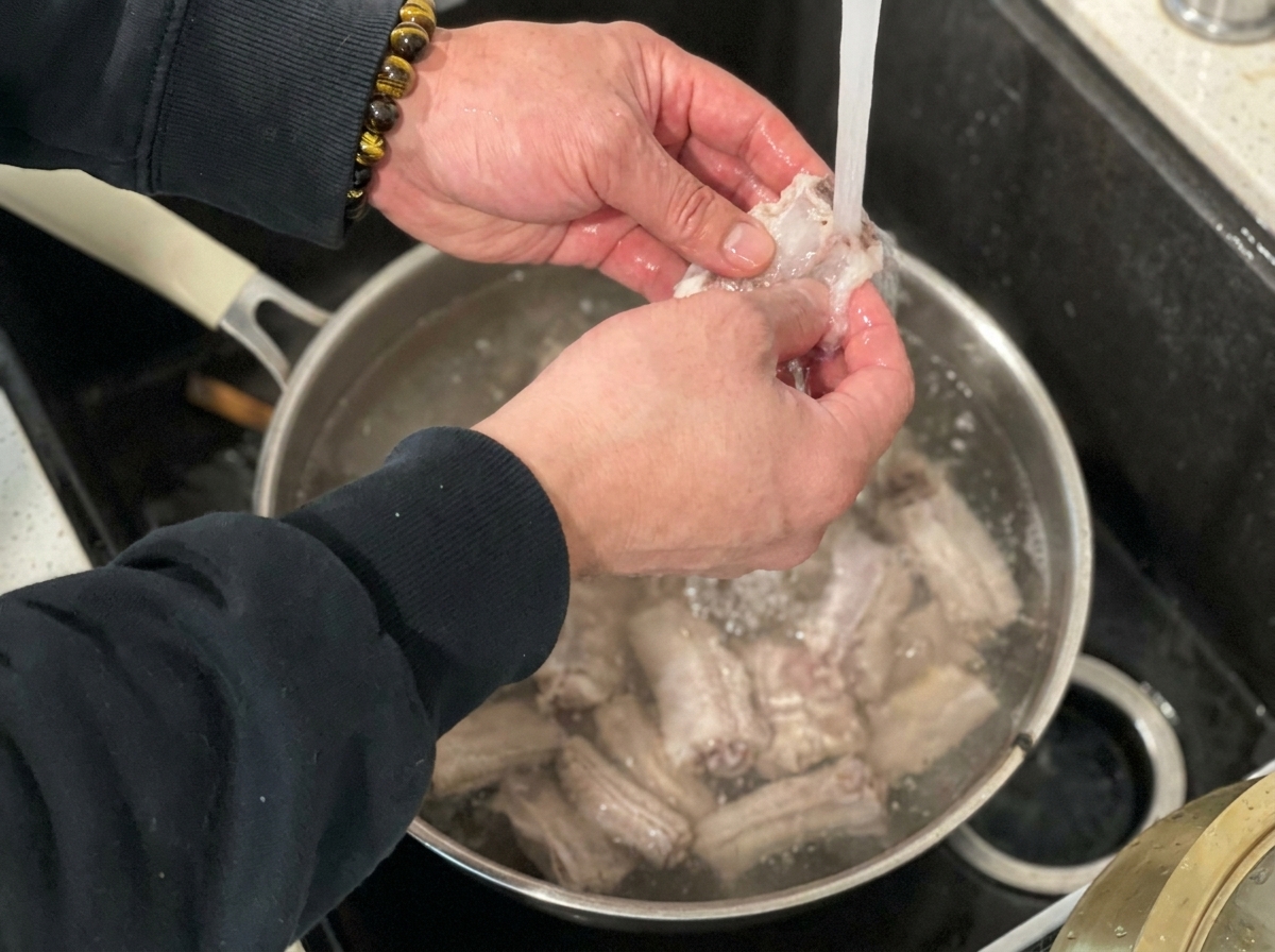 Costine sbollentate sciacquate sotto il rubinetto della cucina.