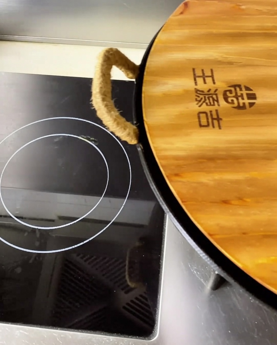 Primo piano di teneri pezzi di costine di maiale brasate in un brodo rosso piccante e saporito dentro un grande wok.
