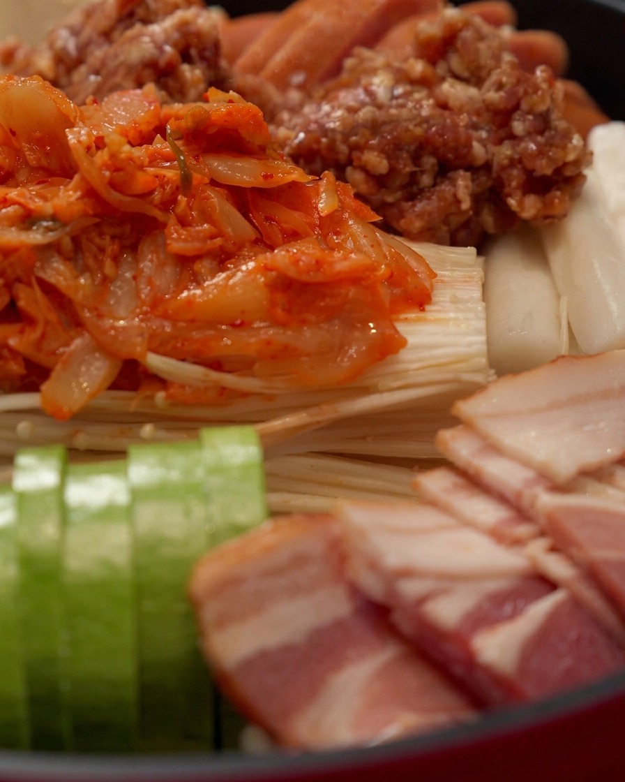 Salsa rossa piccante per hot pot versata sulla parte superiore degli ingredienti disposti.