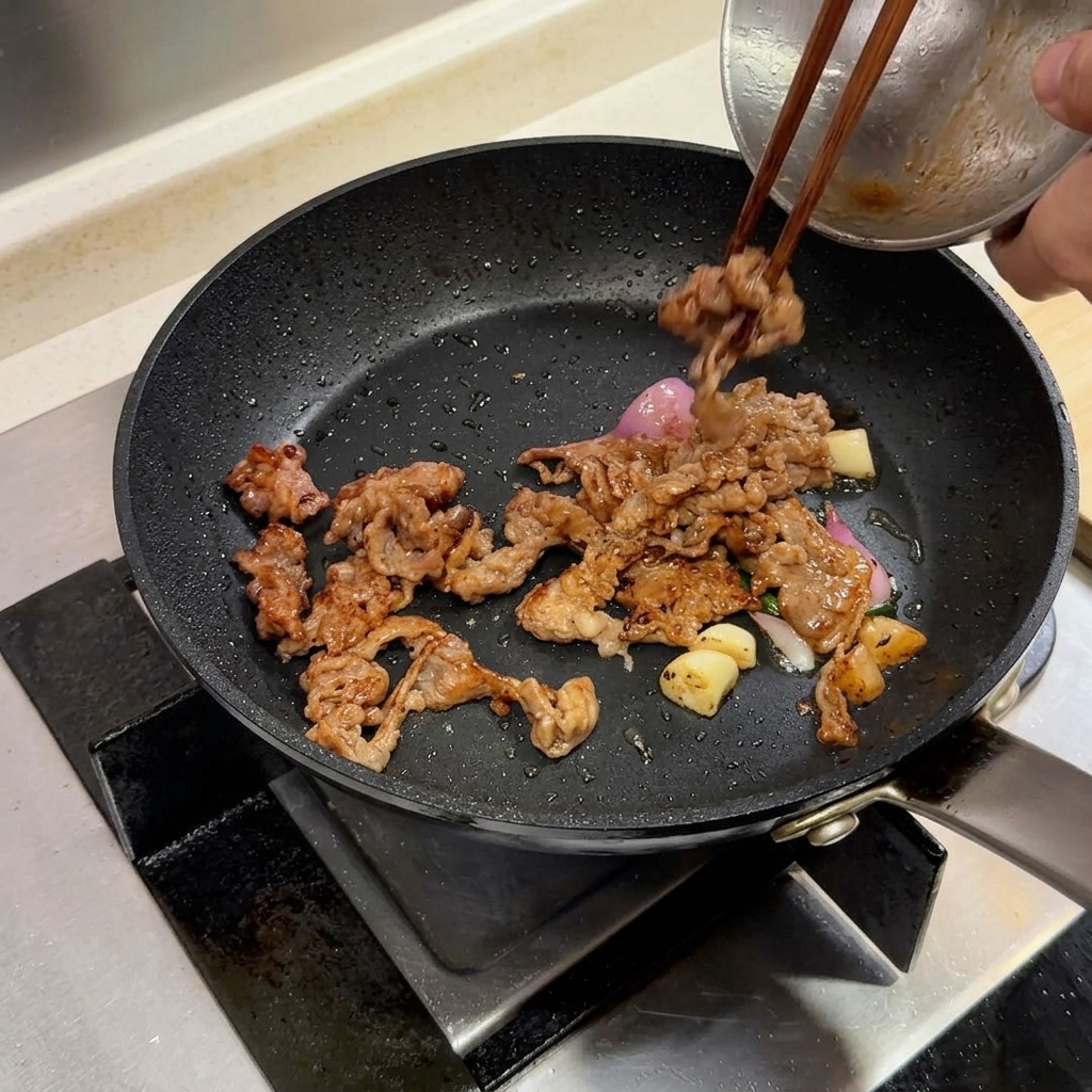 Fette di manzo e aromi in una padella con laggiunta di una noce di burro.