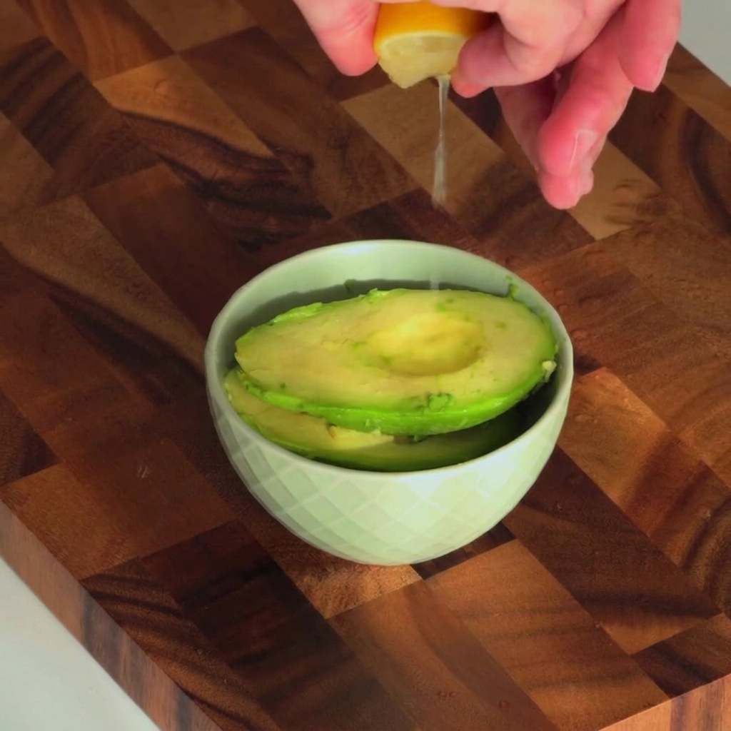 Succo di limone fresco spremuto in una piccola ciotola contenente lavocado.