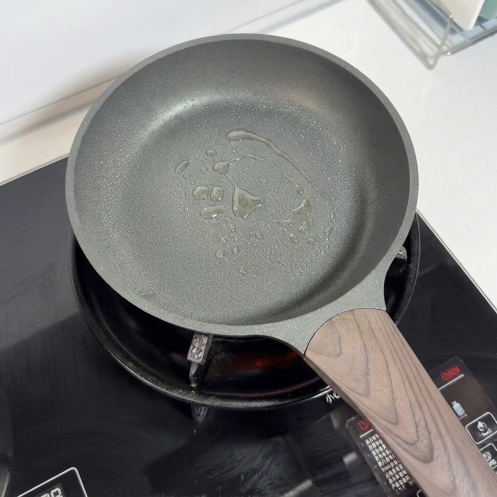 Una padella antiaderente con olio spruzzato sul fondo, pronta per la cottura.