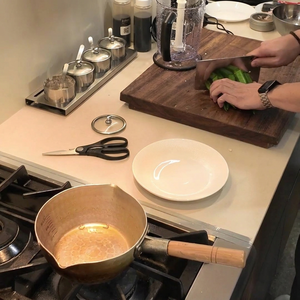 Taglio di okra verde fresca in piccoli pezzi su un tagliere di legno usando una mannaia.