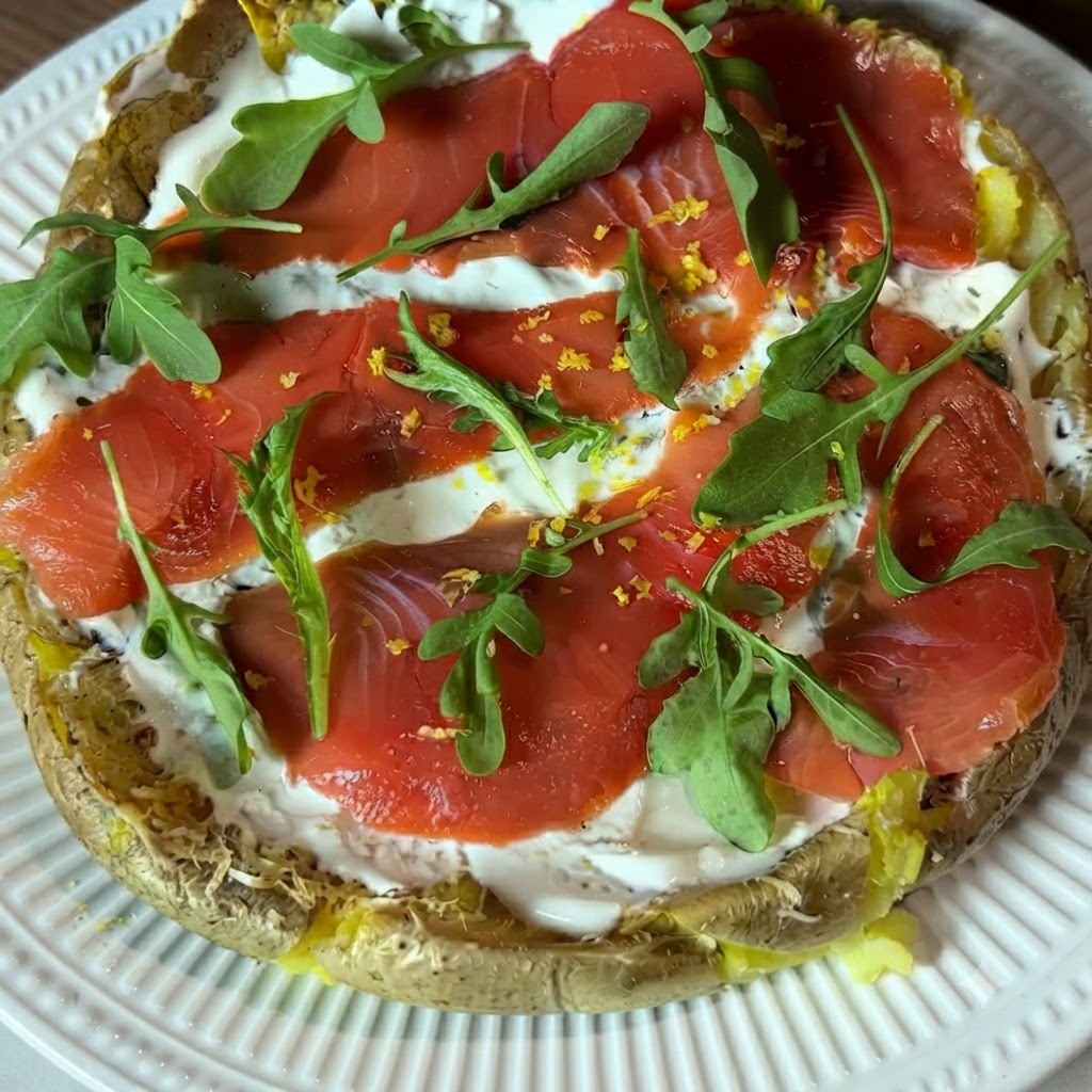 Una vista ravvicinata di scorza di limone giallo grattugiata fresca sparsa sulla pizza di patate guarnita.