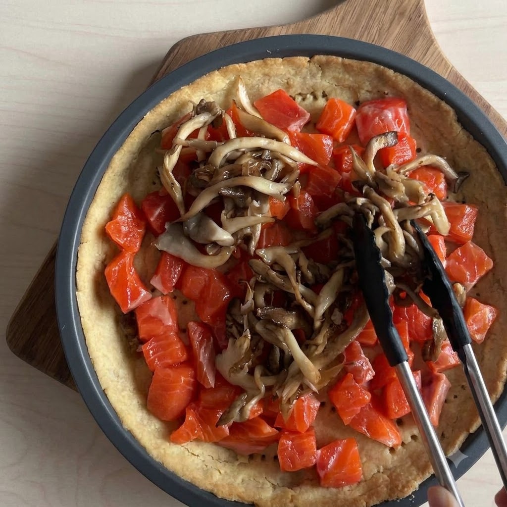 Pezzi di mozzarella fresca strappati a mano sopra un ripieno di torta di salmone e funghi.