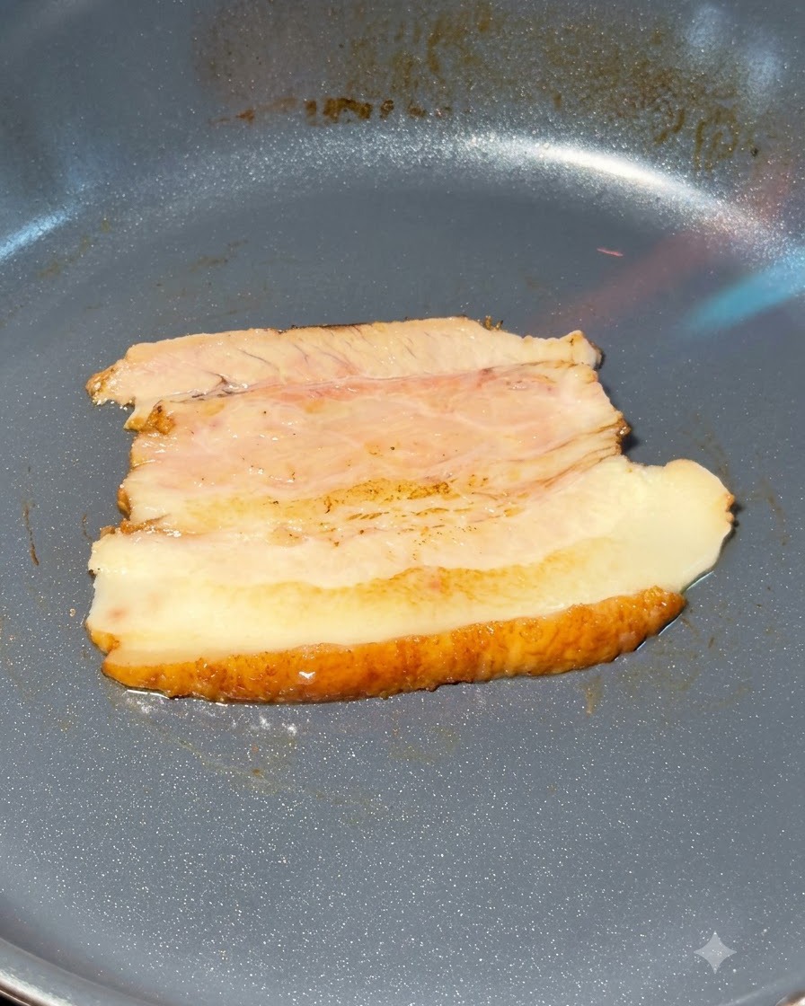 Fette di pancia di maiale chashu flambate in una padella.