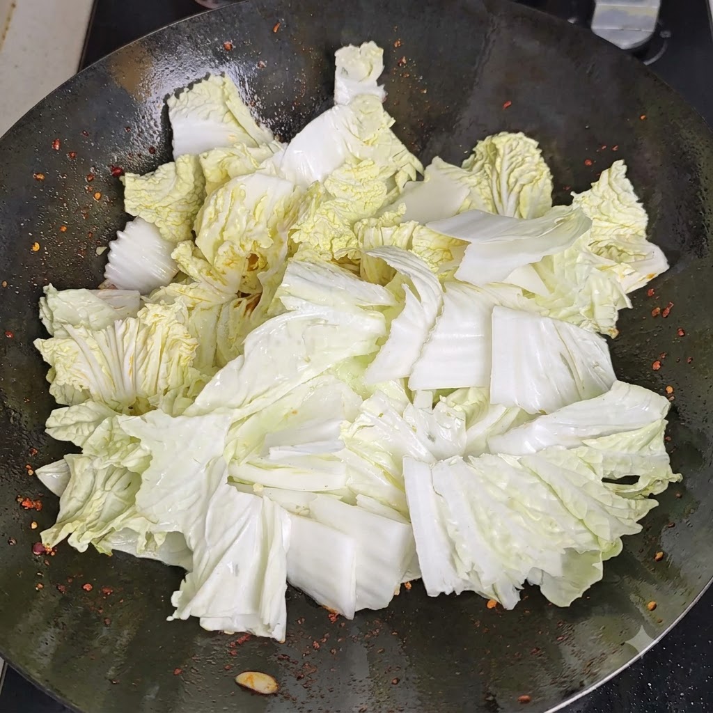 Aceto versato lungo il perimetro riscaldato del wok, che reagisce con la superficie calda.
