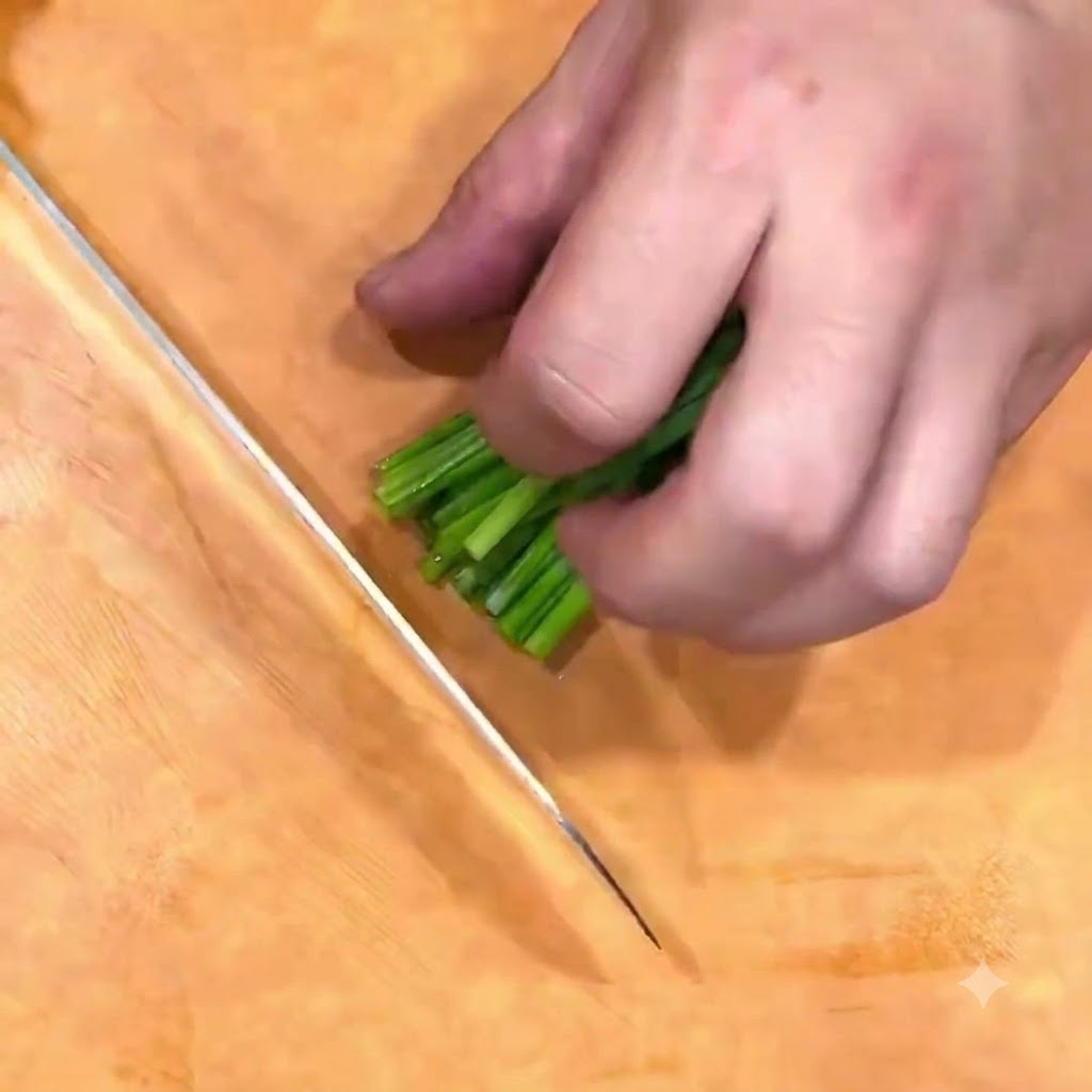 Cipollotti tagliati a fiore su un tagliere di legno con un coltello.
