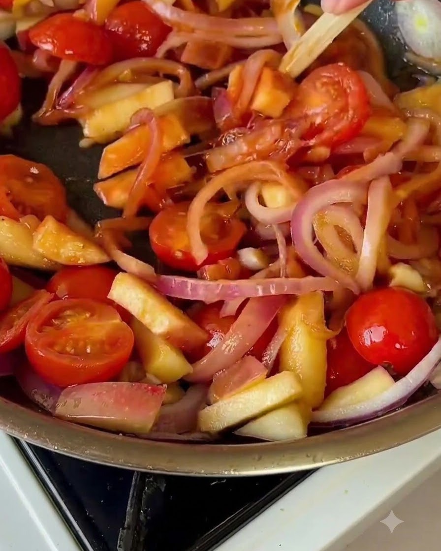 Cavolo verza mescolato nella padella con pomodori e cipolle.