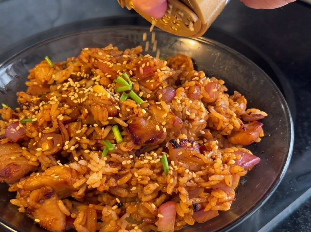 Kimchi aggiunto nella padella e saltato insieme al pollo e alle cipolle.