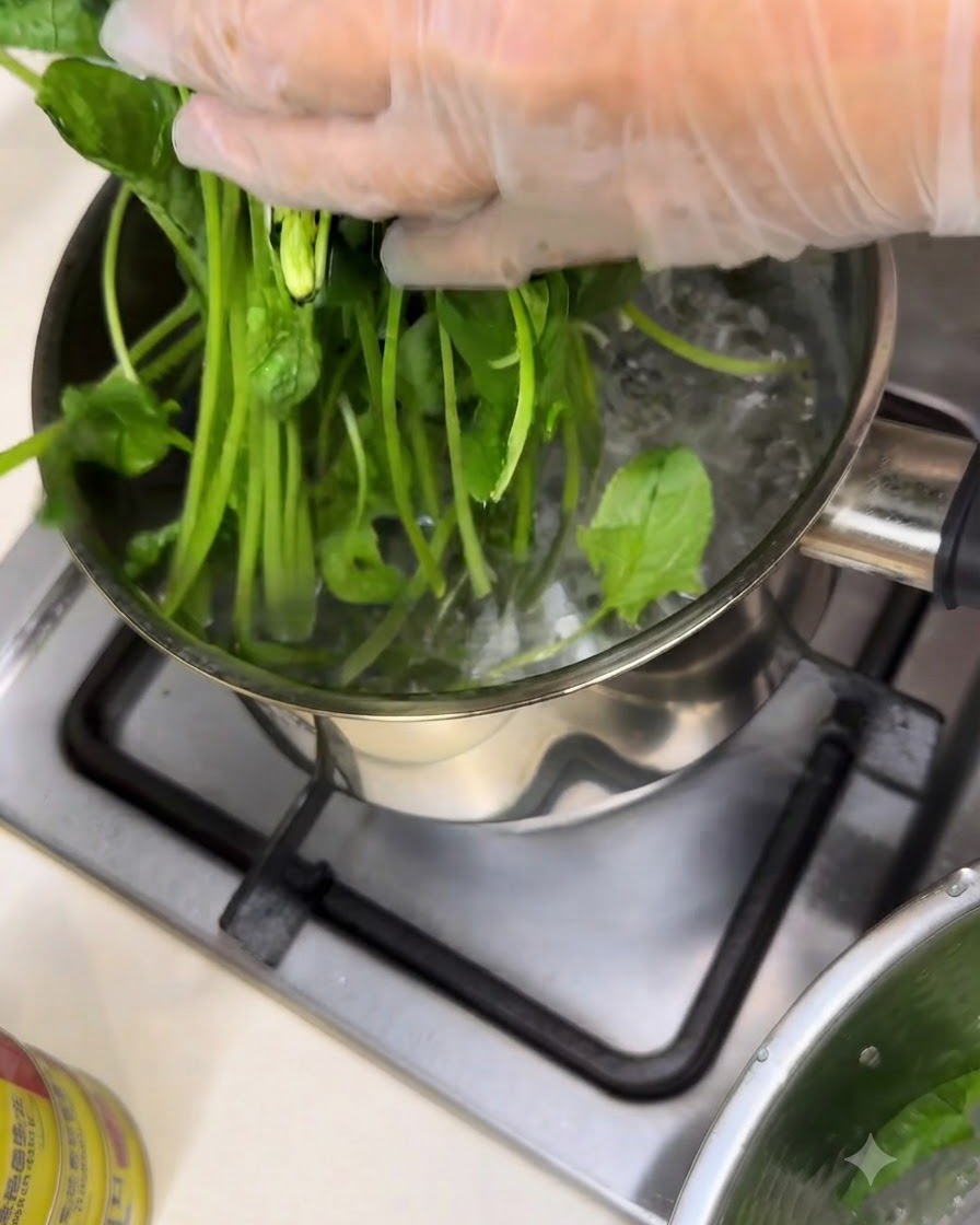 Spinaci freschi che vengono sbollentati in una pentola di acqua bollente su un fuoco della cucina.