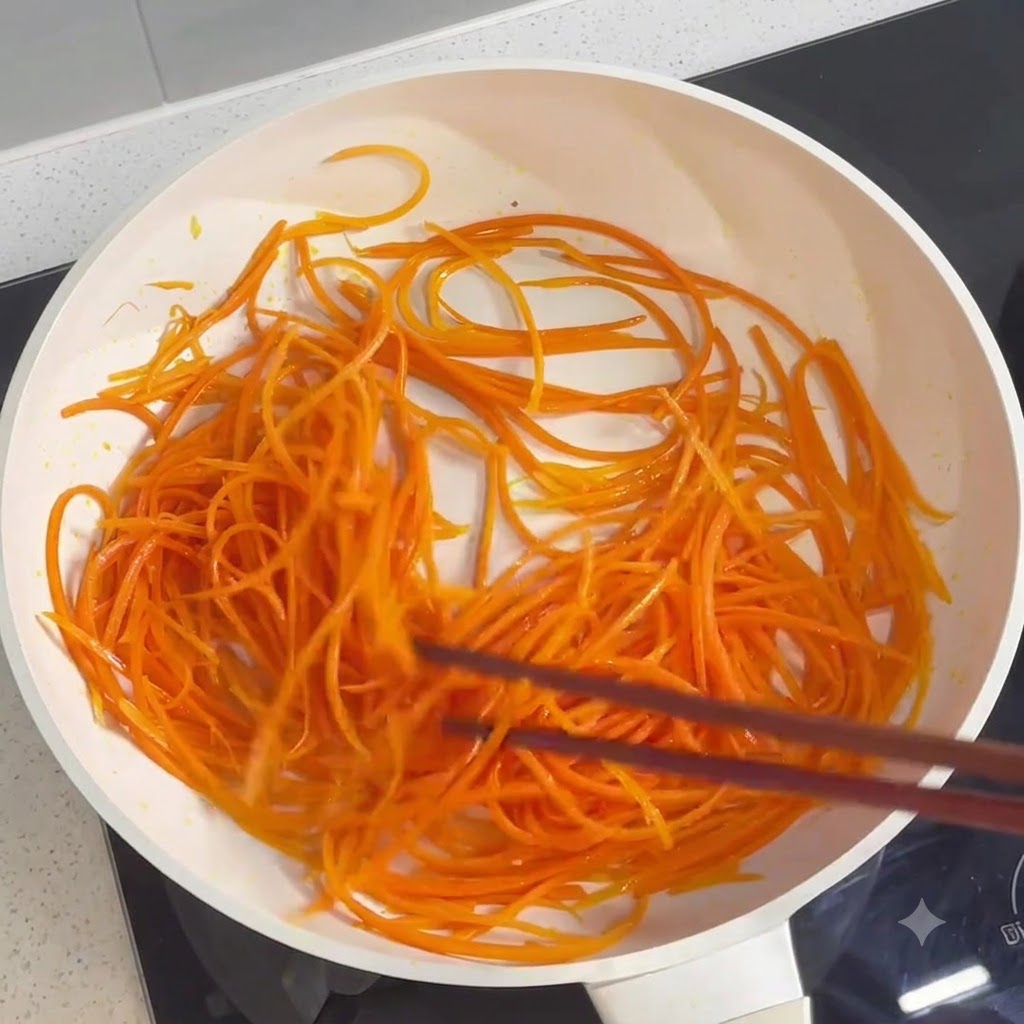 Carote a julienne saltate e cotte in padella con le bacchette.