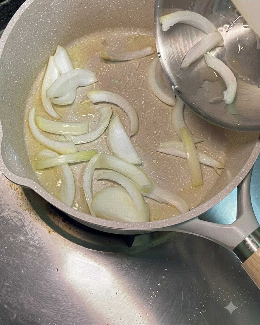 Cipolle bianche affettate versate da una ciotola in acciaio inossidabile in una padella riscaldata con olio da cucina.