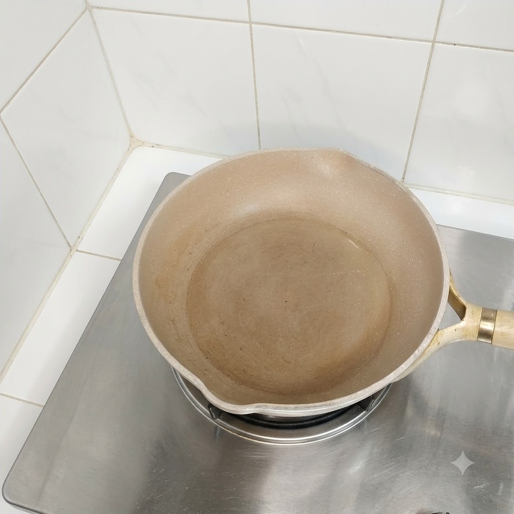 Una padella oleata vuota posizionata su un fuoco della cucina pronta per la cottura.