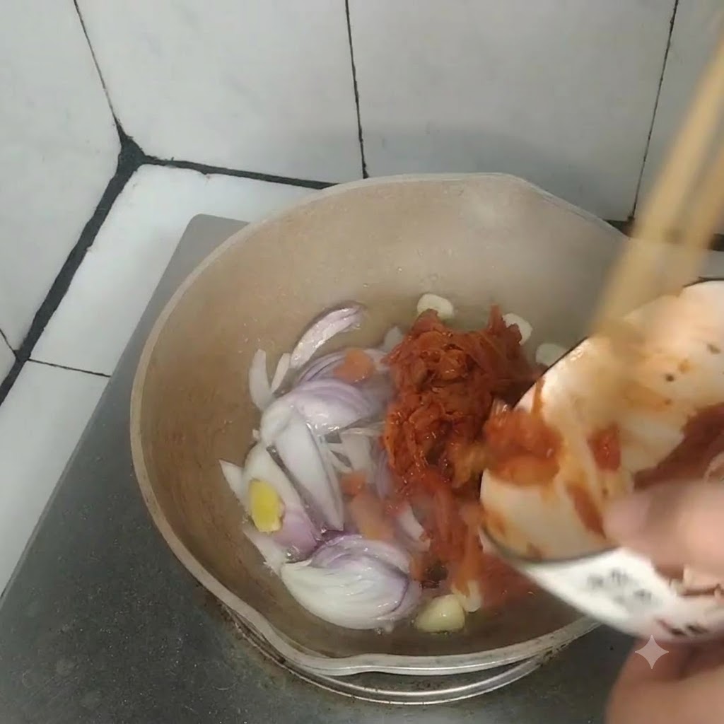 Il kimchi versato da una ciotolina in una padella contenente cipolle, aglio e zenzero soffritti.