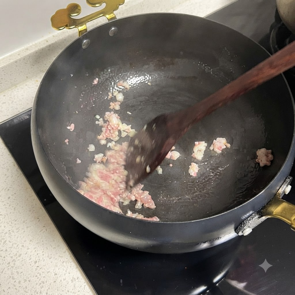 Cipolle rosse a dadini e pomodori a pezzi che cuociono insieme in padella.
